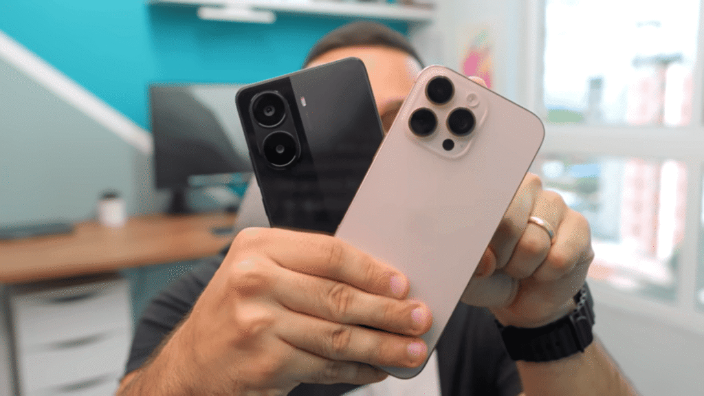 Uma mão segura dois smartphones, um Poco X7 Pro preto e um iPhone 16 Pro Max de cor clara, comparando as câmeras traseiras.