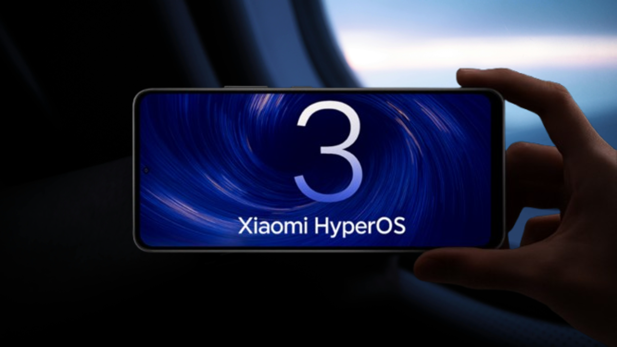 Mão segurando um smartphone com a tela exibindo "HyperOS 3 Gloal" e "Xiaomi HyperOS" contra um fundo escuro e desfocado.